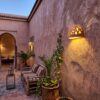 Moroccan Terracotta Floral Cutout Wall Sconce - Installed Room Setting Warm Ambient Interior Illumination