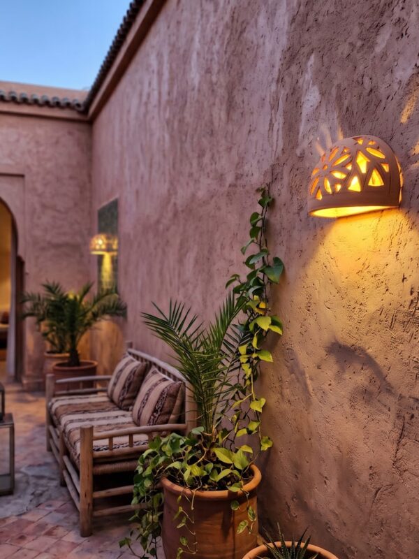 Moroccan Terracotta Floral Cutout Wall Sconce - Installed Room Setting Warm Ambient Interior Illumination